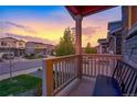 Inviting front porch view showcasing neighborhood homes against a colorful sunset sky at 5311 Blue Lunar Ln, Castle Rock, CO 80104