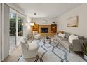Cozy living room featuring a brick fireplace, stylish seating, and a sliding glass door to the yard at 3458 S Norfolk Way, Aurora, CO 80013