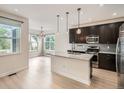 Modern kitchen with granite countertops, stainless steel appliances, and a large island with pendant lighting at 625 Kendall Way, Lakewood, CO 80214