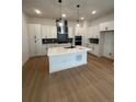 Modern kitchen featuring a large island, white cabinetry, and stainless steel appliances at 203 Washington St, Erie, CO 80516