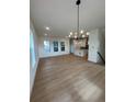 Open-concept living space with hardwood floors, recessed lighting, and a stylish chandelier at 203 Washington St, Erie, CO 80516