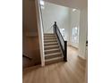 Bright entryway showcasing a modern staircase with hardwood floors and abundant natural light at 203 Washington St, Erie, CO 80516