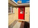 Brick ranch home with a bright red front door at 799 N Holly St, Denver, CO 80220