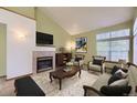 Inviting living room with fireplace, vaulted ceiling and stylish furniture creates a cozy and elegant atmosphere at 9742 E Hawaii Pl, Aurora, CO 80247