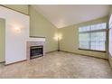 Bright living room features a fireplace, tile flooring, and a large window, offering a comfortable and inviting space at 9742 E Hawaii Pl, Aurora, CO 80247