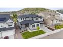 Stunning aerial view of a two-story home with gray siding, a two car garage, and luscious green yard at 359 Rogers Way, Castle Rock, CO 80104