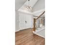 Welcoming foyer features hardwood floors, a staircase with iron railings, and modern lighting fixture at 5557 E Links Cir, Centennial, CO 80122