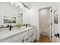 Bright, modern bathroom with double sinks, white cabinets, and an adjacent shower and tub at 42979 Colonial Trl, Elizabeth, CO 80107