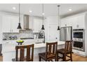 Modern kitchen with stainless steel appliances, island seating, and stylish pendant lighting at 42979 Colonial Trl, Elizabeth, CO 80107