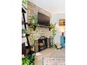 Stone fireplace with mounted TV, black iron fire screen, and plants adding to a cozy ambiance at 209 Wright St # 204, Lakewood, CO 80228