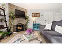 Living room featuring a stone fireplace with TV, comfortable seating, and stylish accents at 209 Wright St # 204, Lakewood, CO 80228