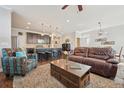 Spacious living room featuring a leather couch, a large TV, and a stone fireplace at 7902 E 49Th Pl, Denver, CO 80238