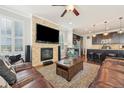Open living room with a stone fireplace, hardwood floors, and a view into the kitchen at 7902 E 49Th Pl, Denver, CO 80238