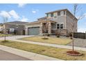 Inviting front exterior with a manicured lawn, tasteful landscaping, and a charming two-story facade, including a two car garage at 18189 House Finch Ln, Parker, CO 80134