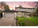Charming two-story home featuring an attached garage and a well-maintained front yard with an American flag at 930 S Dayton St, Denver, CO 80247