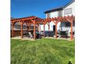 Spacious backyard patio with pergola, seating area, and grill at 580 Mount Massive St, Berthoud, CO 80513