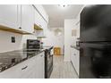 Modern kitchen with white cabinets, granite counters, and stainless steel appliances at 4653 S Lowell Blvd # B, Denver, CO 80236