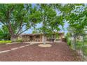 Beautiful brick duplex featuring lush trees, rock landscaping, and charming curb appeal at 3854 Perry St, Denver, CO 80212