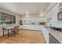 Bright kitchen featuring white cabinets, modern appliances, laminate flooring, and ample counter space at 3854 Perry St, Denver, CO 80212