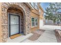 Front entrance featuring stone archway, a white door with window, and a concrete porch at 1822 Painter Dr, Monument, CO 80132