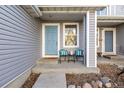 Inviting front porch with blue front door and chairs, creating a relaxing and stylish entrance at 7833 S Kittredge Cir, Englewood, CO 80112