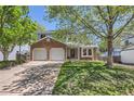 Charming two-story home with brick accents and a well-manicured front yard, shaded by mature trees at 5046 S Evanston St, Aurora, CO 80015
