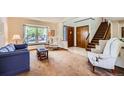 Inviting living room featuring a large window, staircase, and comfortable seating at 5046 S Evanston St, Aurora, CO 80015