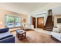 Cozy living room with a bay window seat and a staircase leading to the upper level at 5046 S Evanston St, Aurora, CO 80015