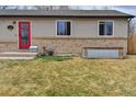 Close-up of the home's exterior highlighting the red front door and tidy landscaping at 11964 W 71St Pl, Arvada, CO 80004