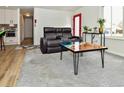 Inviting living room with modern decor, hardwood flooring, and a bright red front door at 11964 W 71St Pl, Arvada, CO 80004