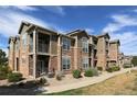 Attractive condo building featuring stacked balconies and charming stone facade, with easy access at 3155 Blue Sky Cir # 16-103, Erie, CO 80516