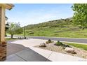 Landscaped front yard featuring xeriscape design elements with a view of a hill in the distance at 7120 Red Mesa Dr, Littleton, CO 80125