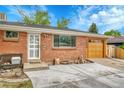Close up of a charming brick home, showing the front door and attached garage at 7940 Appleblossom Ln, Westminster, CO 80030