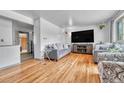 Spacious living room with modern decor, hardwood floors, and large-screen TV at 7940 Appleblossom Ln, Westminster, CO 80030