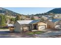Attractive single-story house featuring a charming stone facade, stucco, and a well-maintained artificial lawn at 91 Greeley Blvd, Palmer Lake, CO 80133