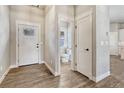 Bright entryway featuring wood-look tile flooring, crisp white trim, and a convenient powder room at 91 Greeley Blvd, Palmer Lake, CO 80133