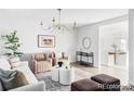 Airy living room offers a sophisticated chandelier, stylish furniture, and seamless transition to the adjacent kitchen at 7154 S Hudson Cir, Centennial, CO 80122