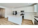 Modern kitchen featuring white cabinets, stainless steel appliances, and a functional center island at 6634 N Malta St, Aurora, CO 80019