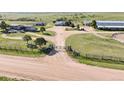 Aerial view of property with gated entrance, barns, and well-maintained pastures at 1705 Outter Marker Rd, Castle Rock, CO 80108