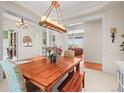 Open dining room featuring a wooden table, hardwood floors, and elegant chandelier lighting at 7003 S Irvington Ct, Aurora, CO 80016
