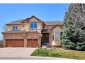Stunning two-story home with a stone and stucco facade, a three-car garage, and a well-manicured front lawn at 6971 S Netherland Way, Aurora, CO 80016