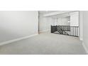 Spacious loft area with plush carpeting and an overlooking staircase at 3378 Backdrop Ct, Castle Rock, CO 80108