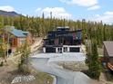 Beautiful modern home featuring a three-car garage, modern design, walls of windows, and views of the forest at 436 N Fuller Placer Rd, Breckenridge, CO 80424