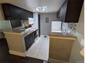 Modern kitchen with dark cabinetry, granite countertops, stainless steel appliances, and white tile floors at 1863 S Pitkin Cir # B, Aurora, CO 80017