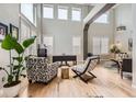 Bright living area with soaring ceilings, clerestory windows, hardwood floors, and stylish accent chairs at 989 Graland Pl, Highlands Ranch, CO 80126