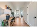 Bright entryway with wood floors, stylish console table, and a view of the home's interior at 2840 E 102Nd Pl, Thornton, CO 80229