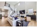 Spacious living room with soaring ceilings, a fireplace, large windows, and modern decor at 2840 E 102Nd Pl, Thornton, CO 80229