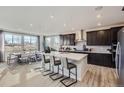 Modern kitchen boasts an island with seating, dark cabinetry, and a separate dining area with bright natural light at 14123 Bunny Hop Ln, Parker, CO 80134