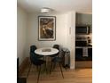 Bright dining area with a modern table, stylish chairs, and view into the kitchen at 155 S Pennsylvania St # 209, Denver, CO 80209