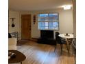 A cozy living and dining area with warm hardwood floors, a dark media center and dining table at 155 S Pennsylvania St # 209, Denver, CO 80209